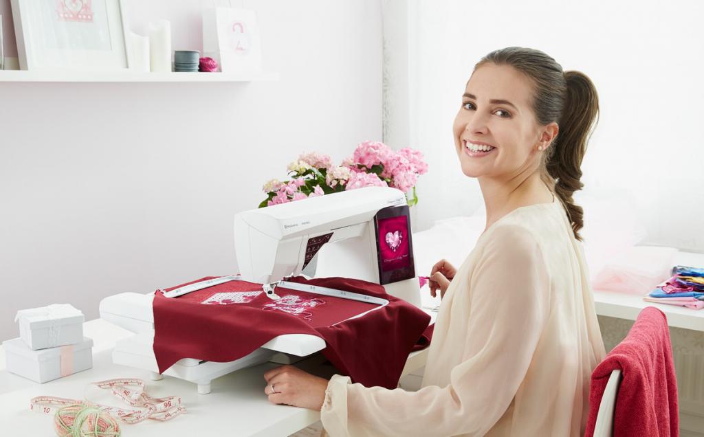 Улыбающаяся женщина рядом со швейной машинкой