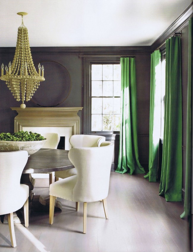 Зеленые шторы разбавляют серый интерьер гостинной