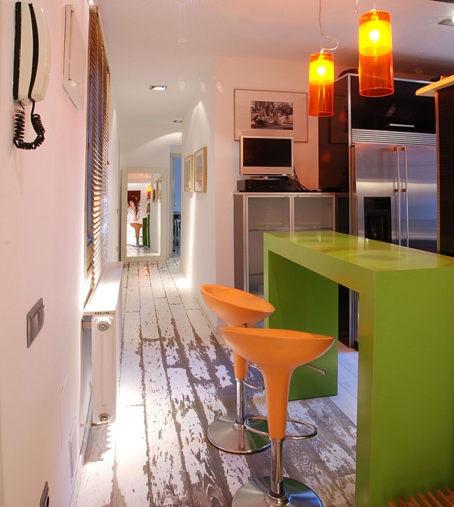 Оранжевые стулья в компании с оранжевыми светильниками и зеленым столом добавляют сочности и нескучности обычной кухне