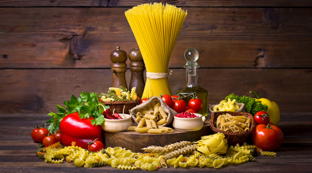 Variety of uncooked pasta and vegetables