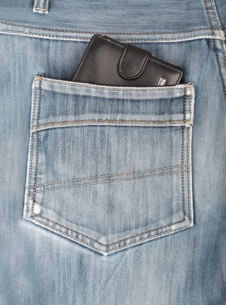 Черный кожаный бумажник, торчащий в заднем кармане джинсовой ткани — стоковое фото