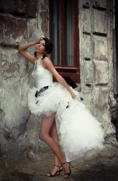 Красивая невеста, прислонившись к стене старого здания — стоковое фото