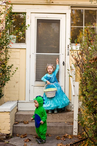 Двое детей в костюмах трюк или лечения — стоковое фото