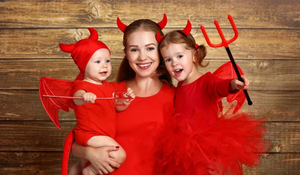 Счастливая семья с дьяволом костюмы готовит для Хэллоуина — стоковое фото