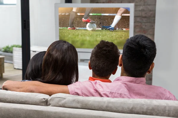 Семья смотрит телевизор на диване — стоковое фото