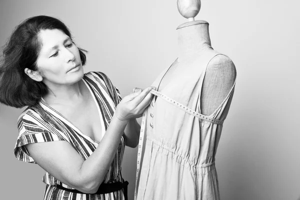 Женщина шьет платье на манекен — стоковое фото
