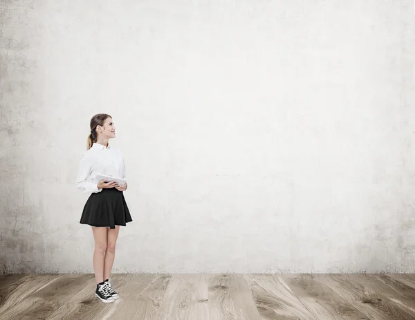 Девочка в комнате с бетонной стеной — стоковое фото
