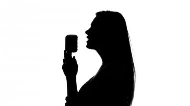 Woman sings a song and waves his hair. Close up. Silhouette. White — стоковое видео