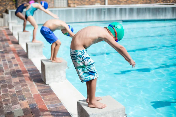 Маленькие пловцы готовы прыгать в бассейн — стоковое фото