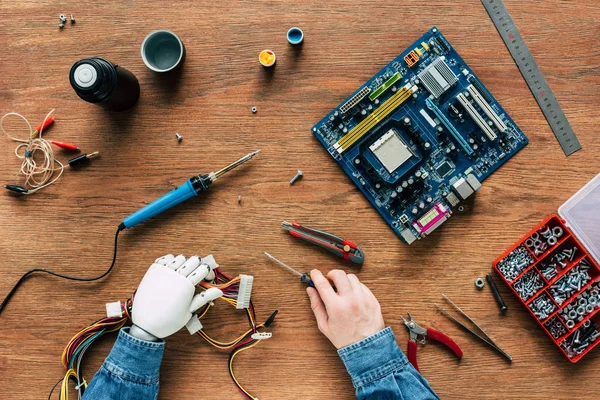 Cropped Image Man Prosthetic Arm Holding Wires Screwdriver Surrounded Instruments — стоковое фото