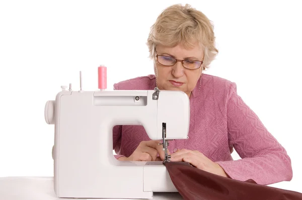 Пожилая женщина шьет на швейной машины — стоковое фото