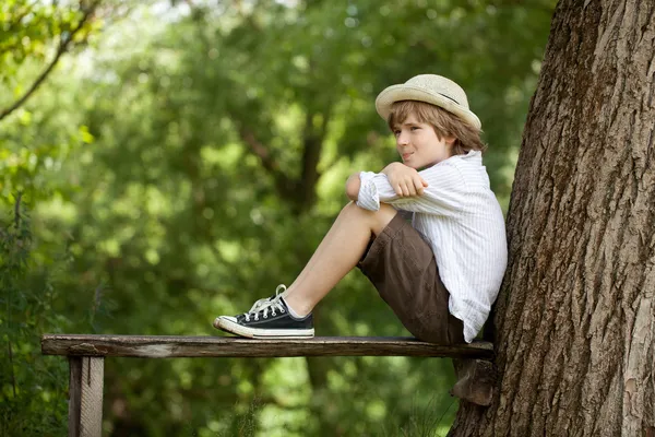 Мальчик сидит на лавочке — стоковое фото